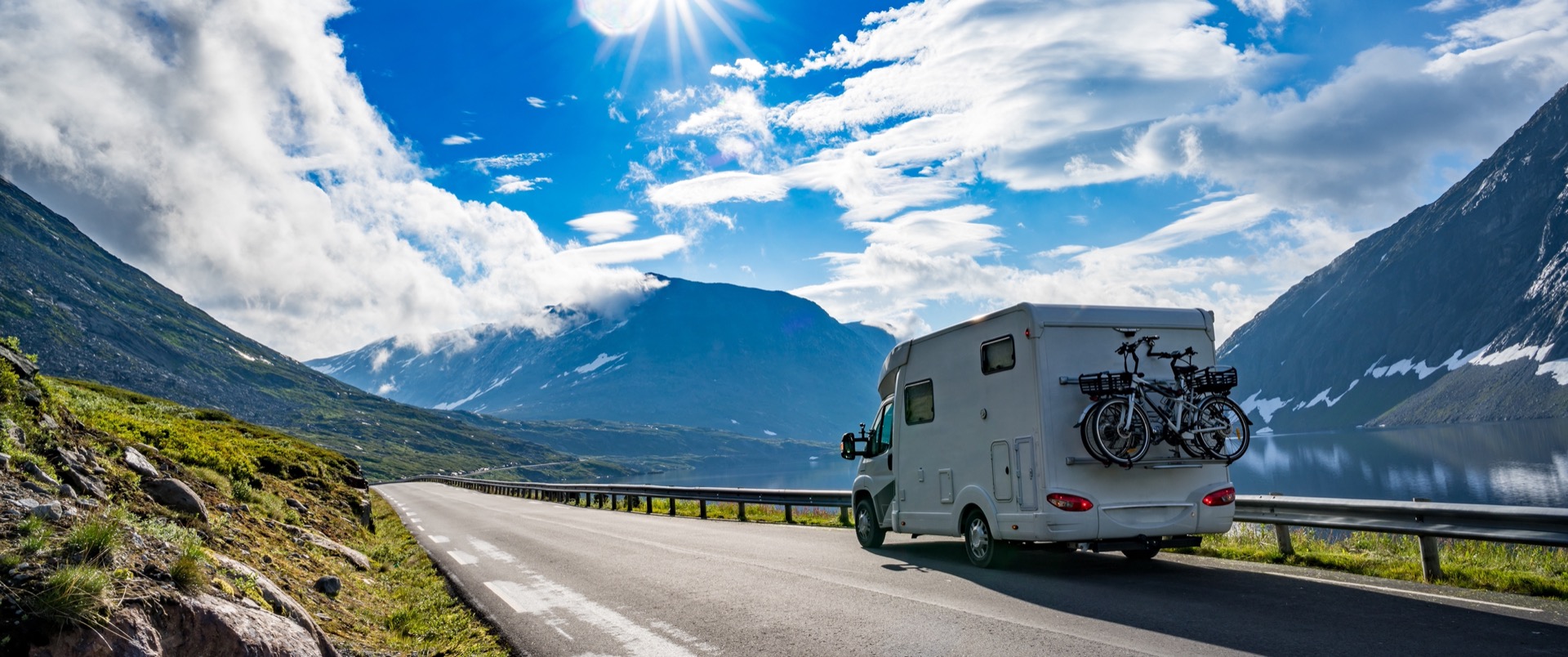 Wohnmobil mit Fahrradträger auf Bergstraße am Fjord in Norwegen – Wohnmobil kaufen bei Caravan.de